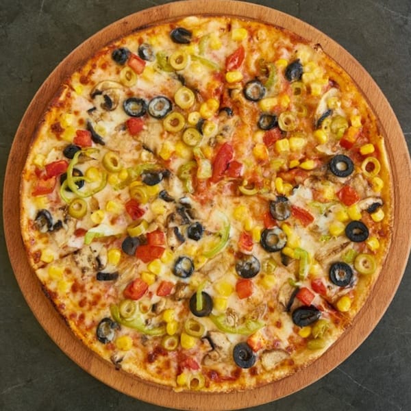 Wild Pepper Pizza with corn, olives, mushrooms, bell peppers, and tomatoes on a wooden board.