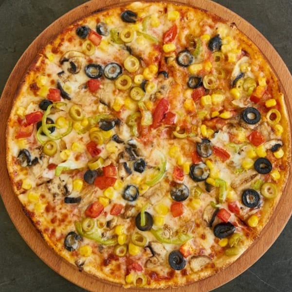 Wild Pepper Pizza's vibrant vegetarian pizza with olives, corn, peppers, and mushrooms on a wooden board.
