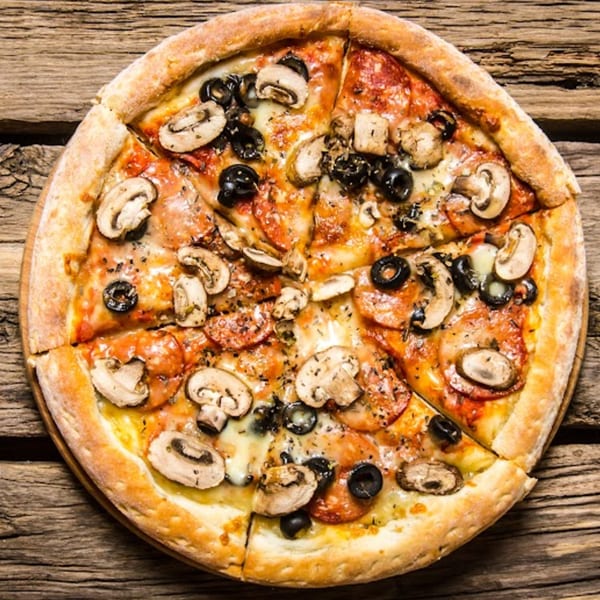 Wild Pepper Pizza with mushrooms, black olives, and pepperoni on a rustic wooden table.